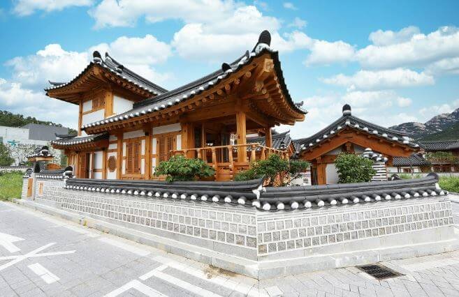 A beautiful exterior of a Hanok under the blue sky, representing an amazing traditional Korean accommodation
